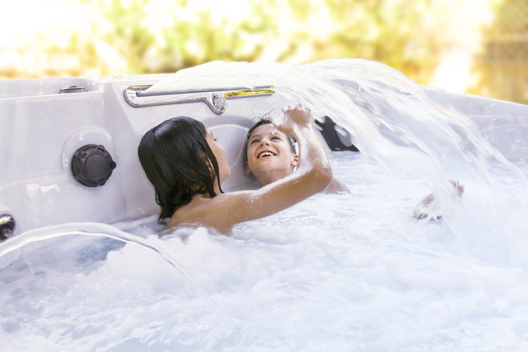 Two people in a hot tub with bubbles, surrounded by nature, factory direct hot tub